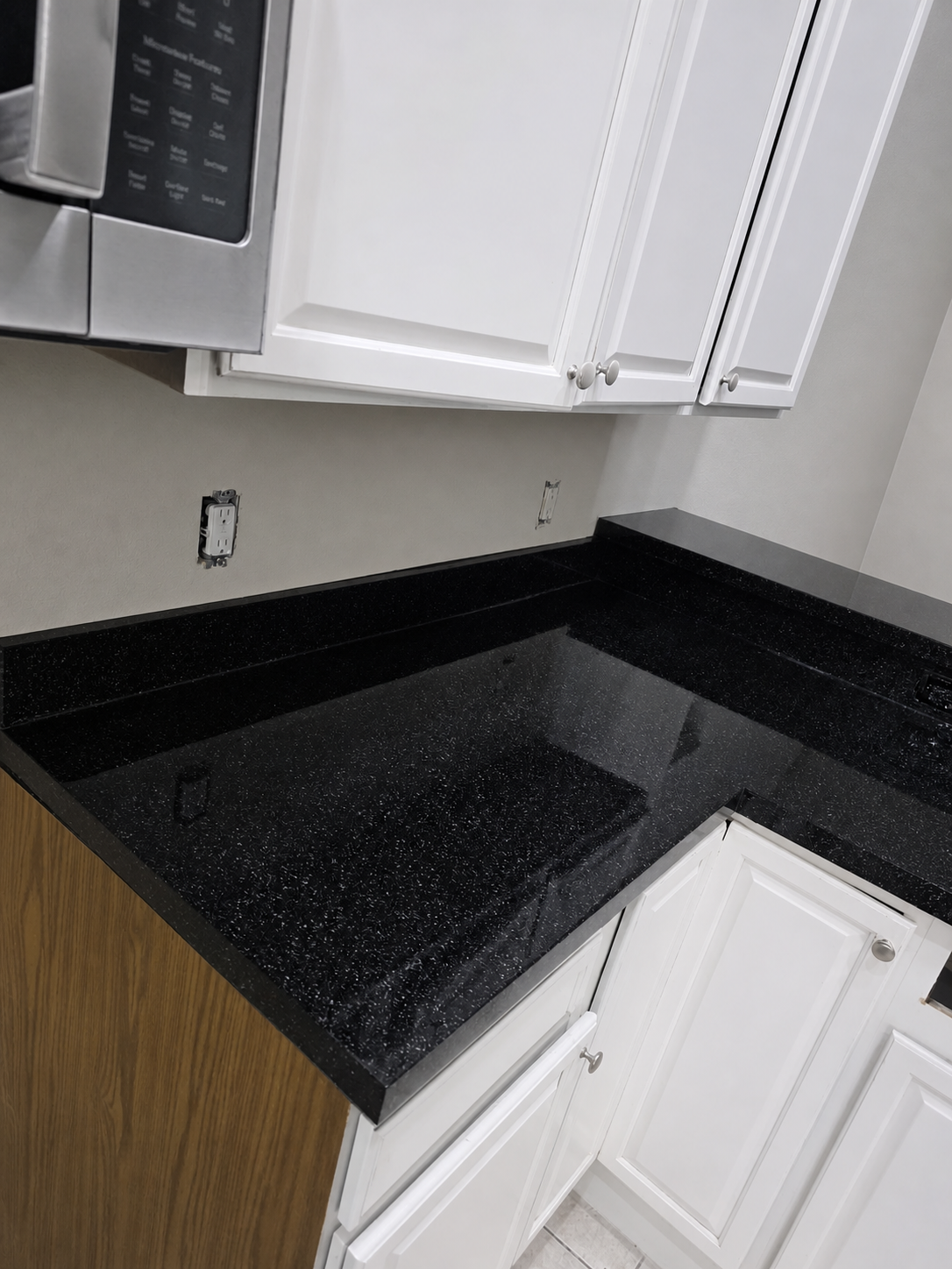 Detailed view of black refinished counter beneath white cabinets